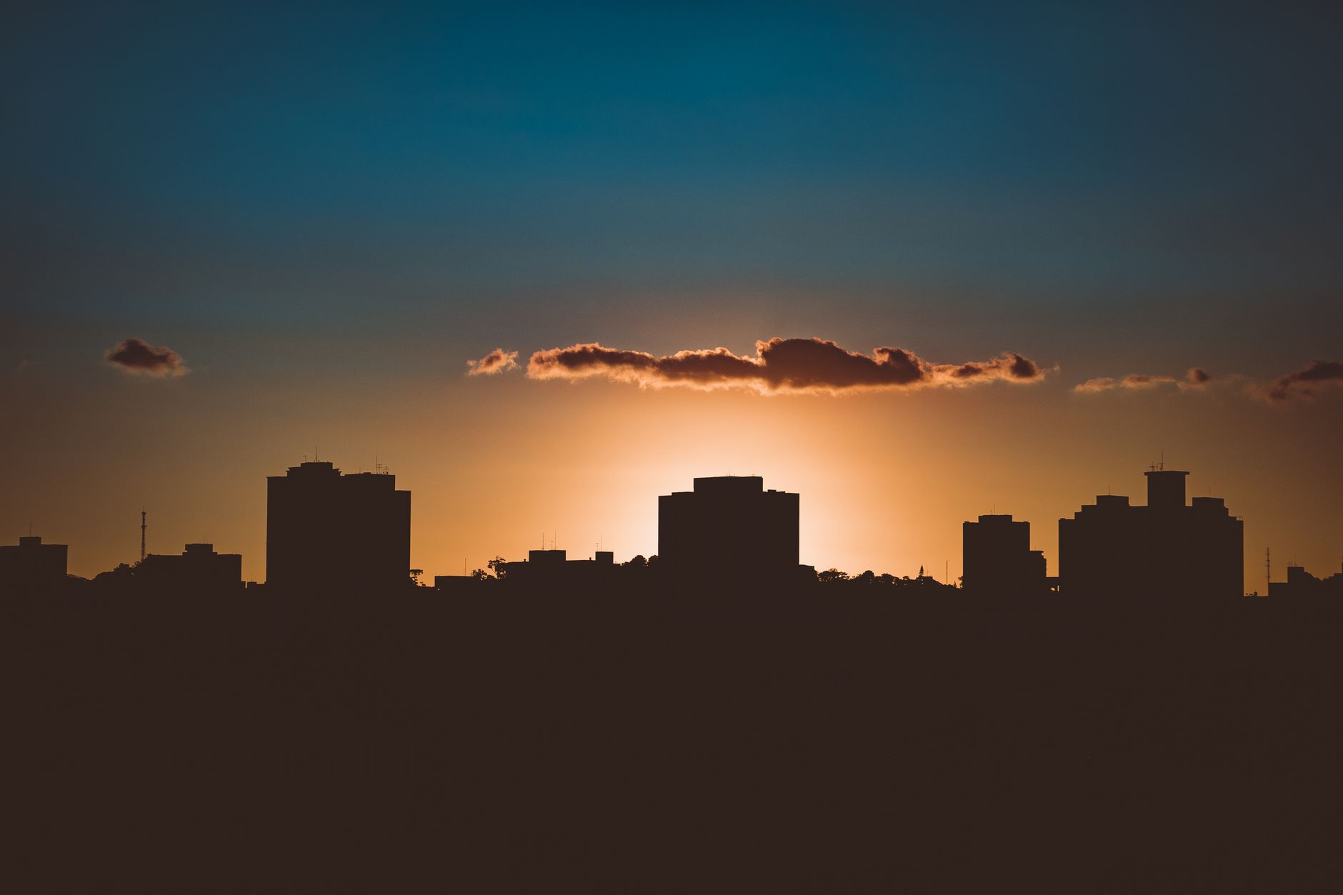 Silhouette spectaculaire de la ligne d'horizon d'une ville avec le soleil en contre-jour pendant l'heure dorée créant une silhouette saisissante.